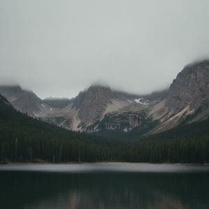 A mountain lake under a flat grey sky